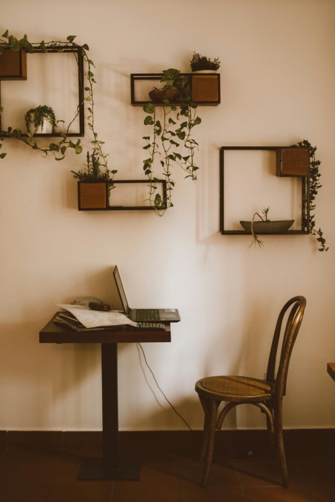 chaise et petite table en bois avec cadres en bois au mur et plantes