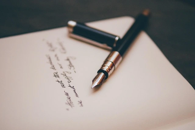 stylo plume encre ouvert posé sur une feuille blanche